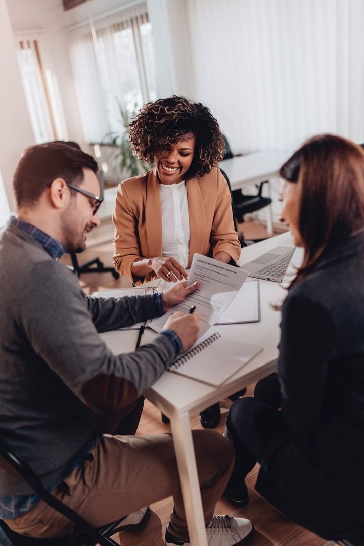 A group of people are sitting around a table looking at papers.